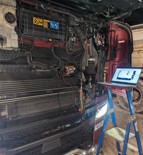 Un camion en cours de reprogrammation moteur, avec un ordinateur portable affichant les données en temps réel