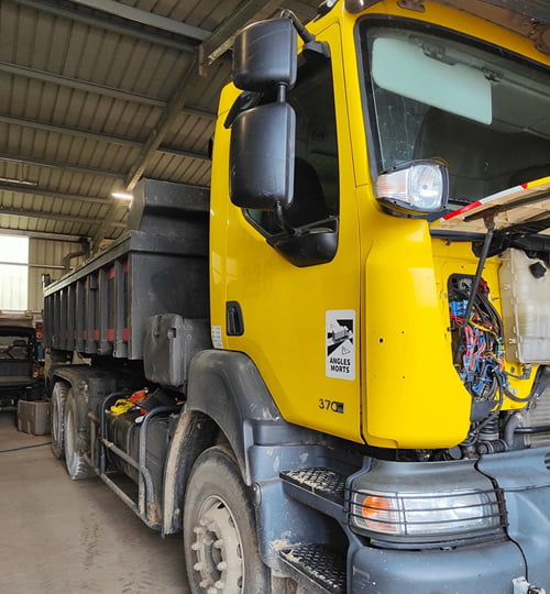 Un camion jaune dans un atelier, prêt pour la reprogrammation.