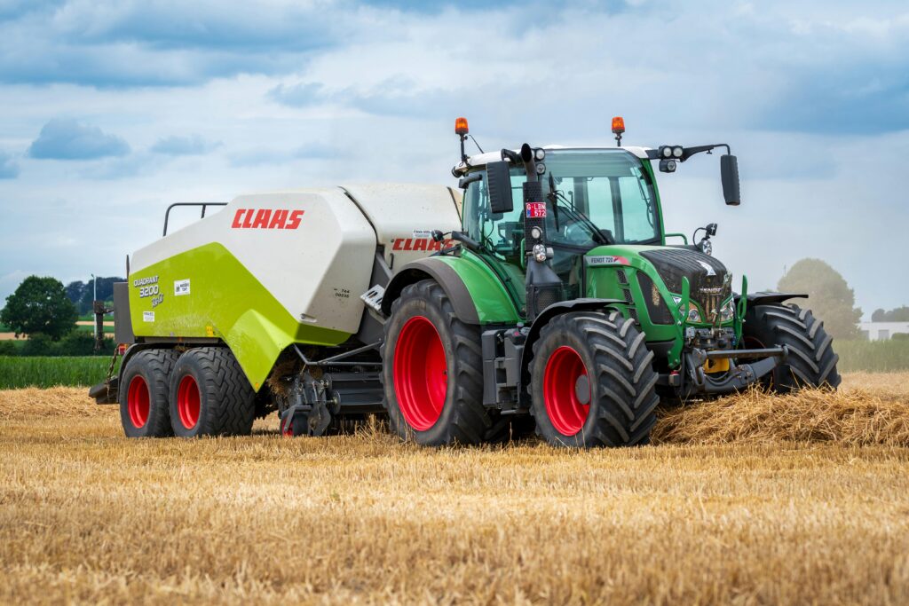 Tractor working in a wheat field during harvest season, showcasing agricultural machinery.