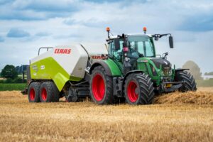 Tractor working in a wheat field during harvest season, showcasing agricultural machinery.